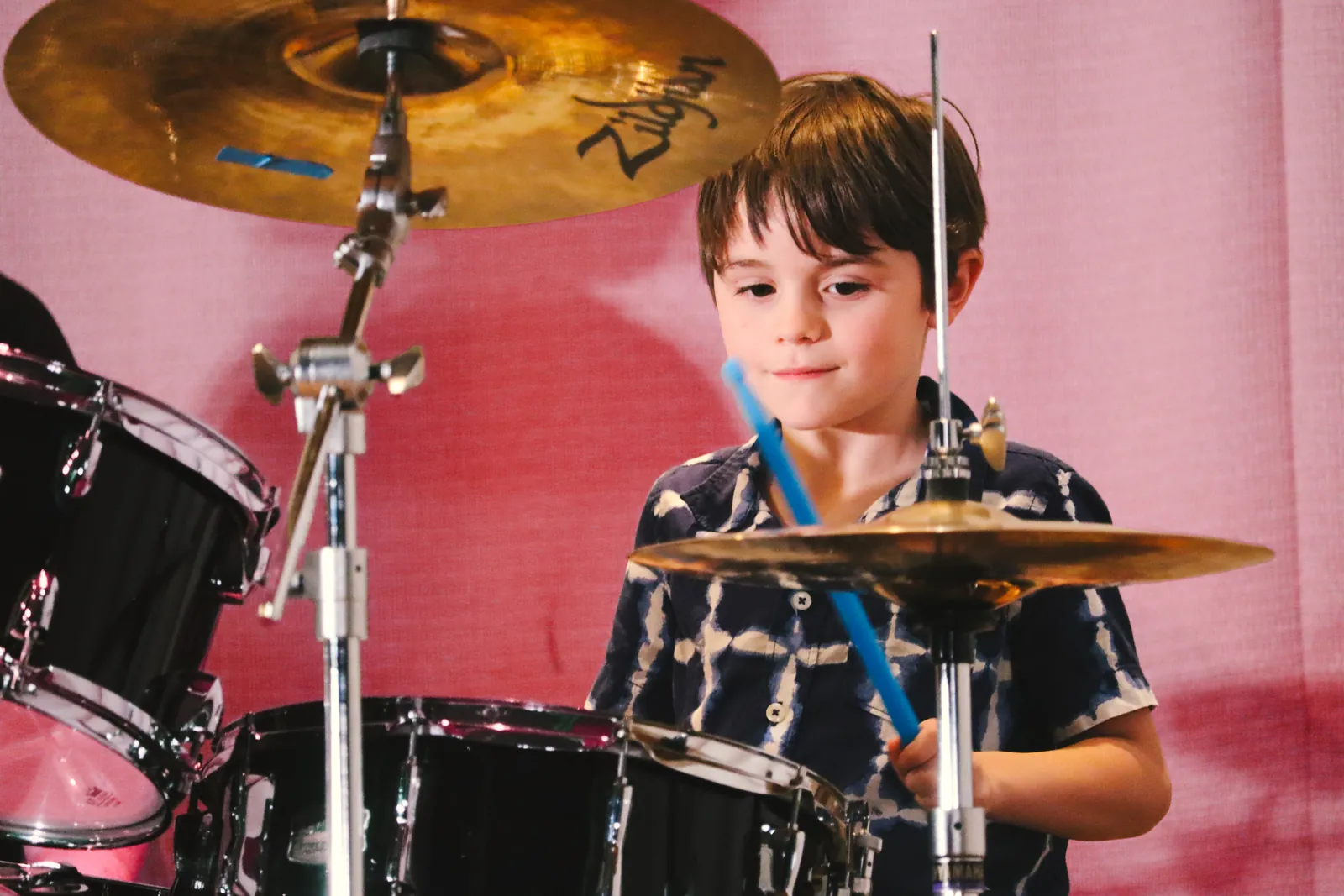 A CBY Academy student playing the drums on stage